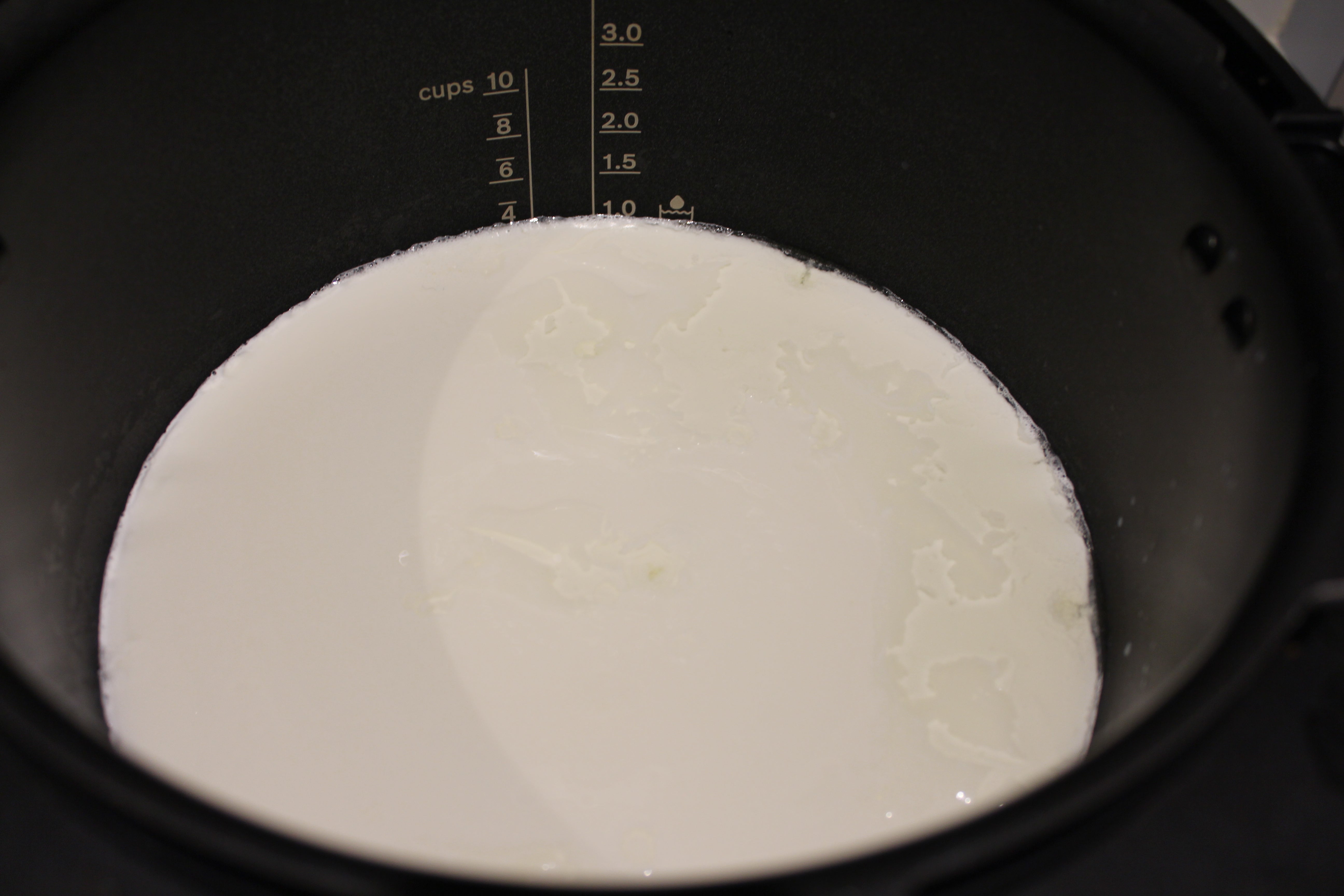 Milk at a marked level inside Bosch AutoCook pot.Bosch AutoCook with milk at 3 cups mark.