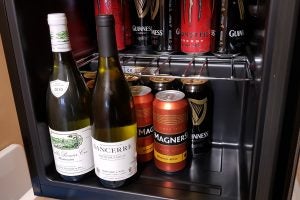 Wine and cans of beer inside a compact refrigerator.