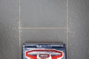 Shark DuoClean vacuum cleaning a messy tiled floor