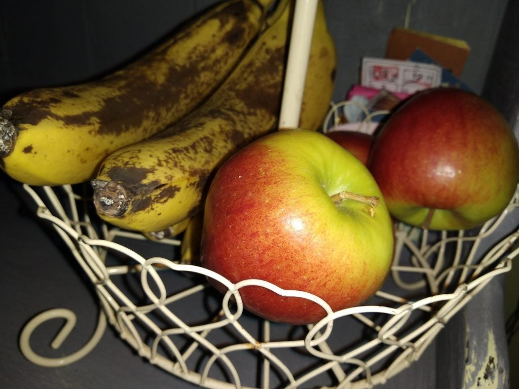Ripe bananas and apples in a wire fruit basket.Elephone U Pro photo of a river through trees with litter.Collection of classic Capcom video games for Sega Saturn.