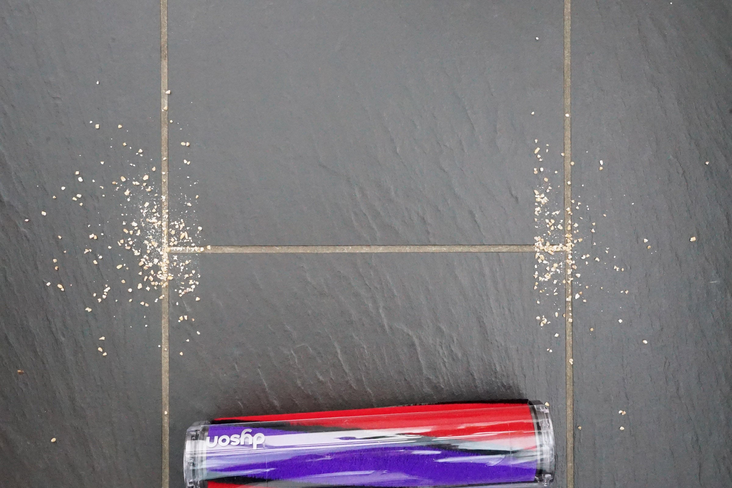 Dyson Cyclone V10 vacuum cleaning debris from floor.