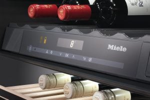 Miele wine conditioning unit with temperature display and bottles.