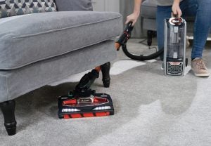 Shark DuoClean vacuum in use cleaning under sofa