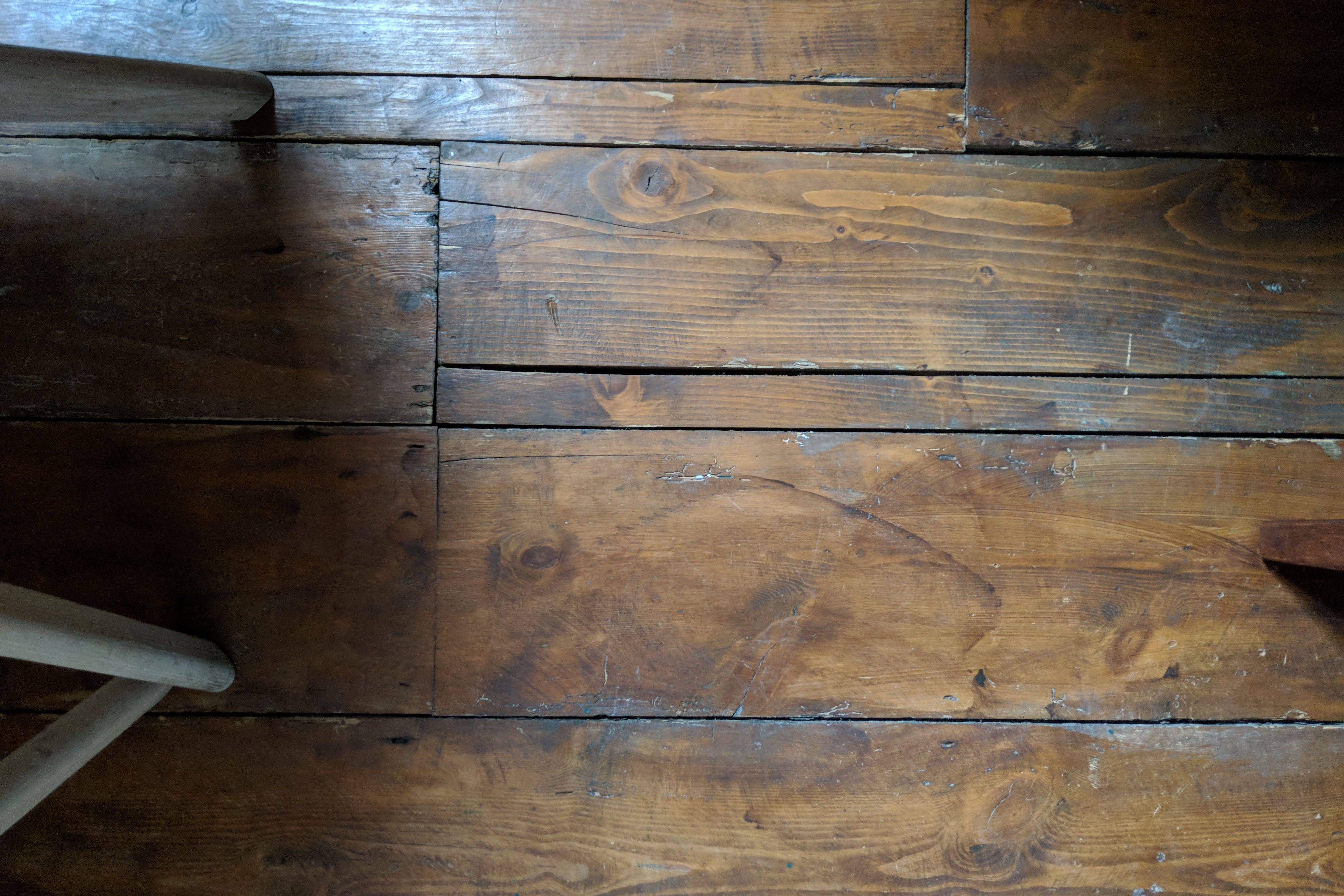 Wooden floor with dust and debris before vacuuming.