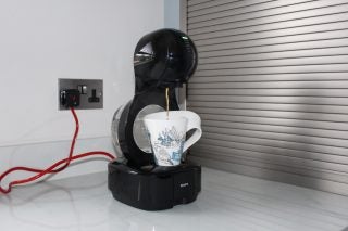 Nescafé Dolce Gusto Lumio coffee machine in use on kitchen counter.
