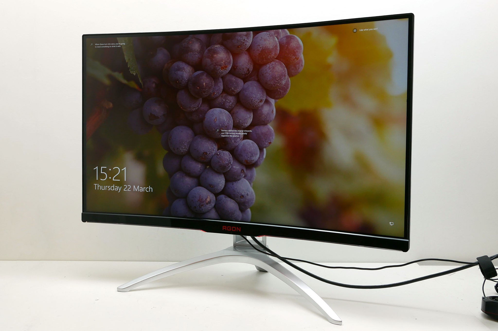 AOC AG322QCX gaming monitor displaying a colorful image with grapes.