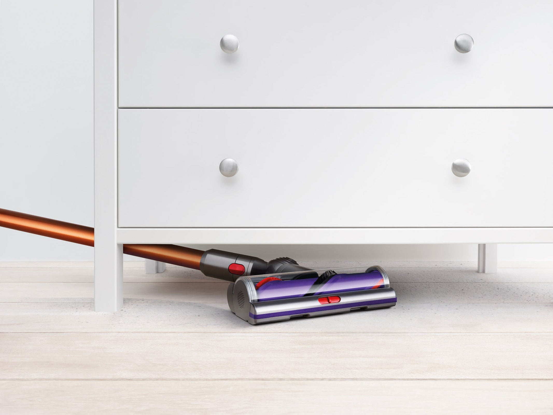 Dyson Cyclone V10 Absolute vacuum cleaning under a dresser.