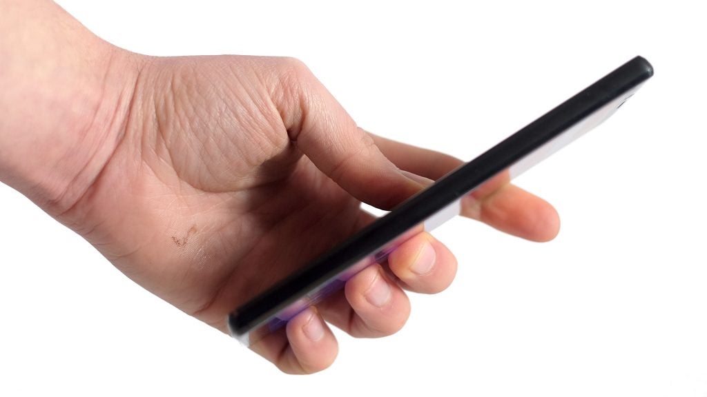 Hand holding a Doogee Mix 2 smartphone against a white background.