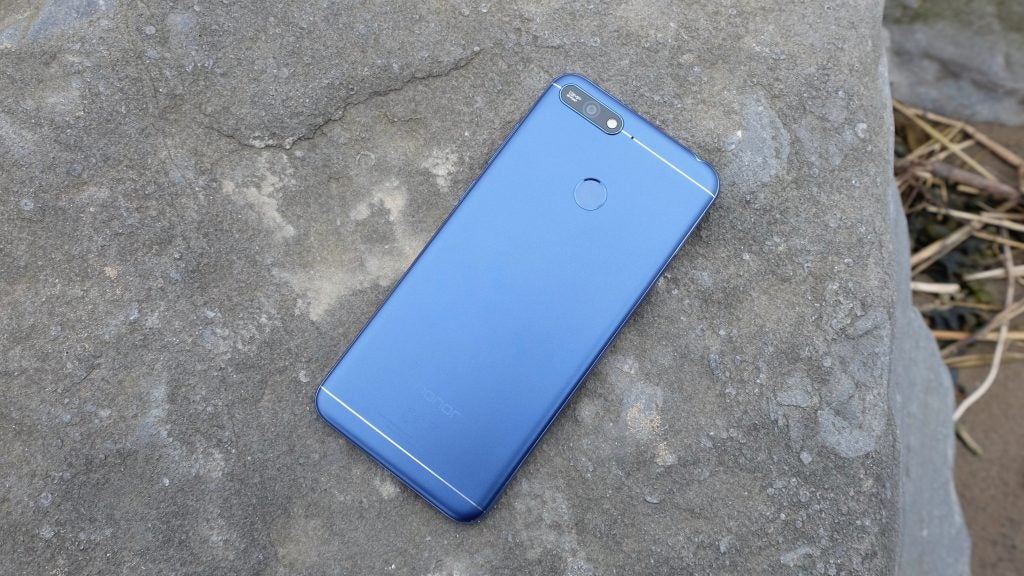 Honor 7A smartphone lying on a stone surface.