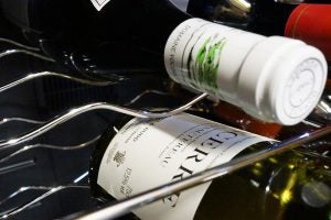 Close-up of wine bottles in Baumatic wine cooler racks.
