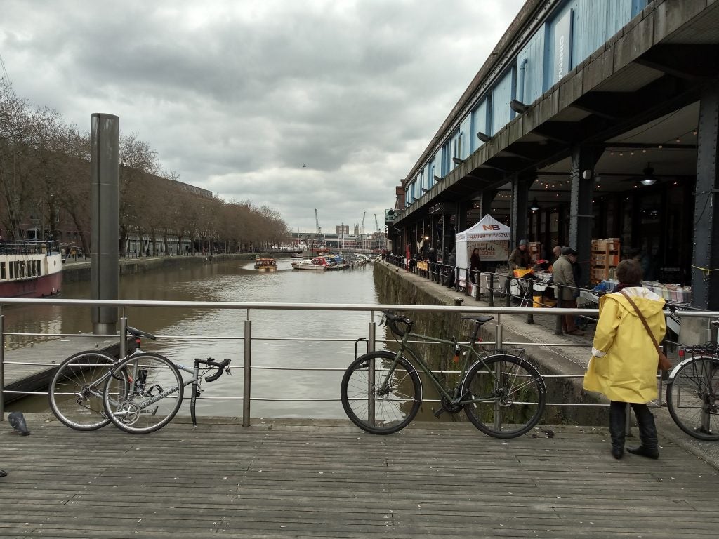 Outdoor scene with bicycles along a riverside boardwalk