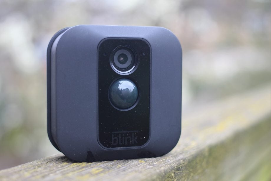 Blink XT outdoor security camera on a wooden ledge.