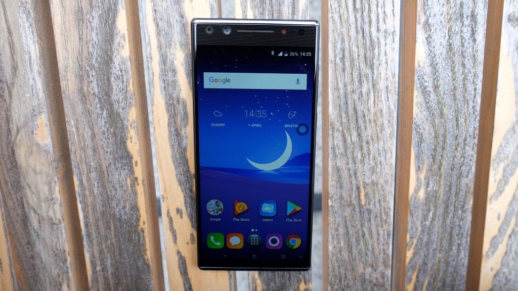 Alcatel 5 smartphone displayed against a wooden background.