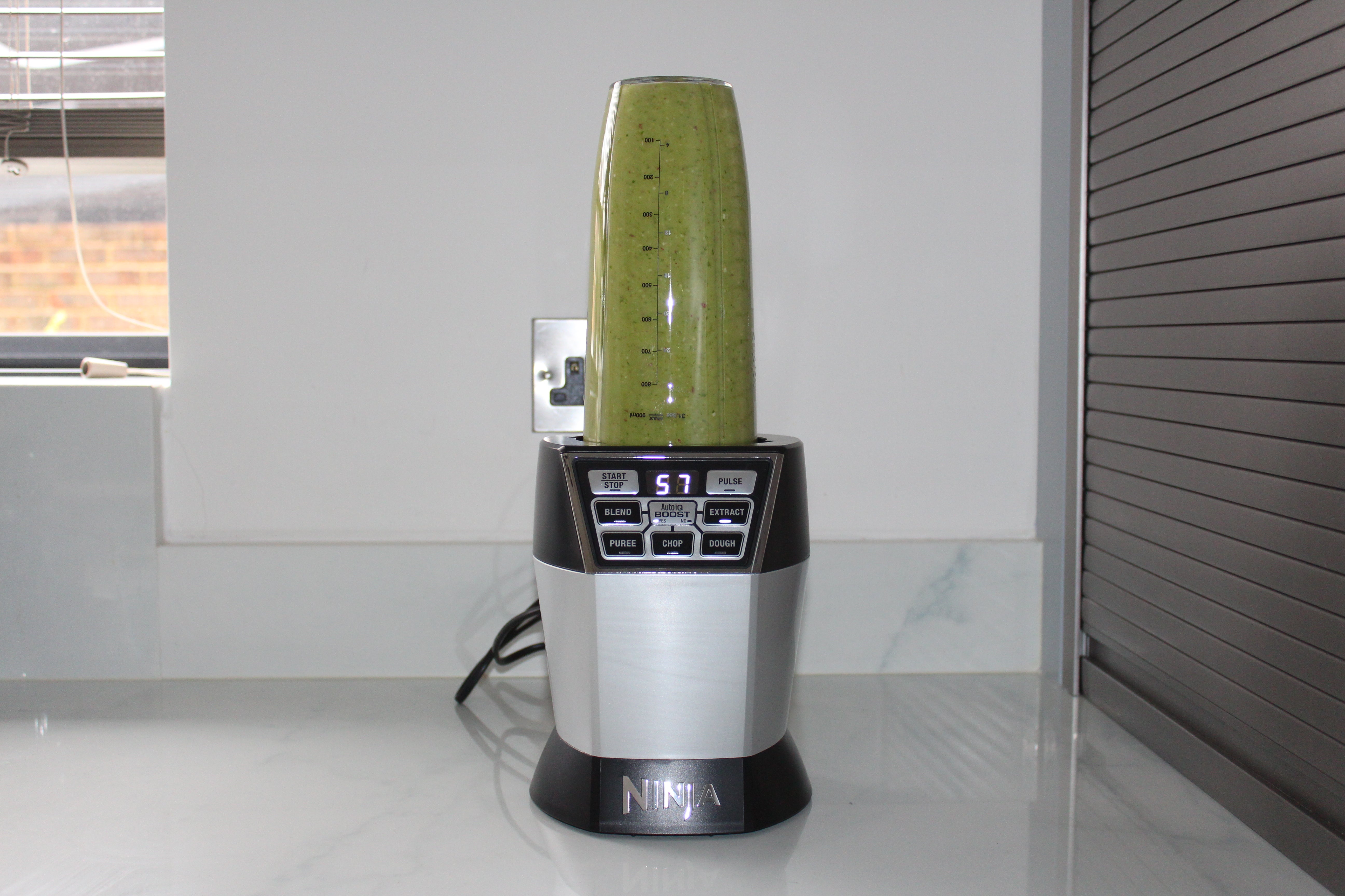 Ninja Ultimate Chopper with green smoothie on kitchen counter.