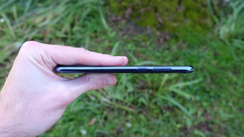 Hand holding Honor 7A smartphone showing its side profile.