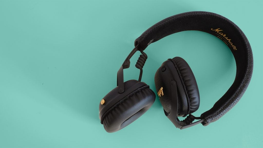 Marshall MID ANC Bluetooth headphones on teal background.