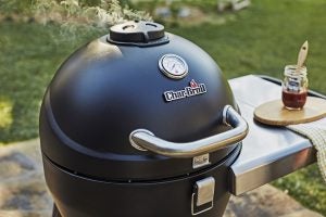 Char-Broil Kamander Charcoal Grill with smoke rising.