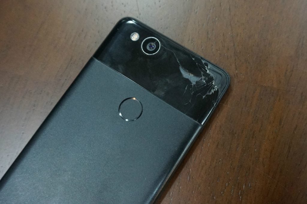 Google Pixel 2Back panel view of a gray-black Pixel 2 kept facng down on a table with it's top right corner broken