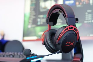 HyperX Cloud Alpha gaming headset on a desk with computer screen.