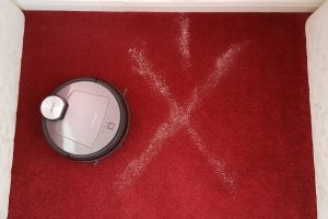 Ecovacs Deebot R95 robot vacuum cleaning a red carpet.