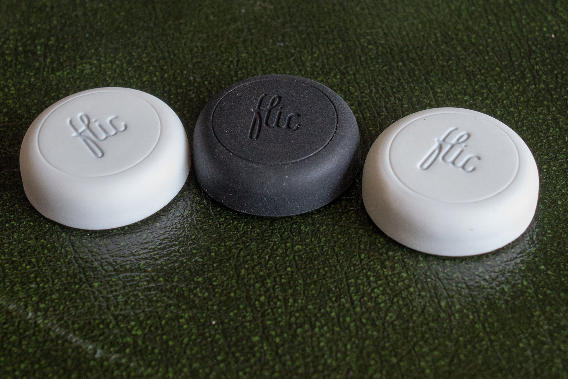 Three Flic smart buttons in white and black colors.