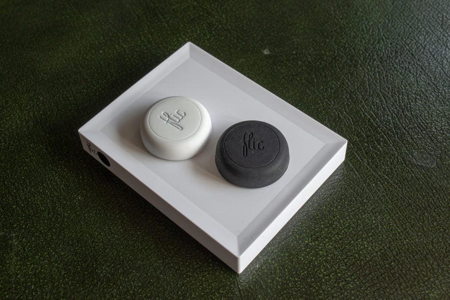 Flic Hub smart buttons on display, one white and one black.