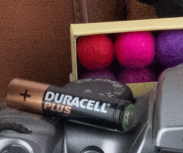 Duracell battery next to colorful balls inside a bag.