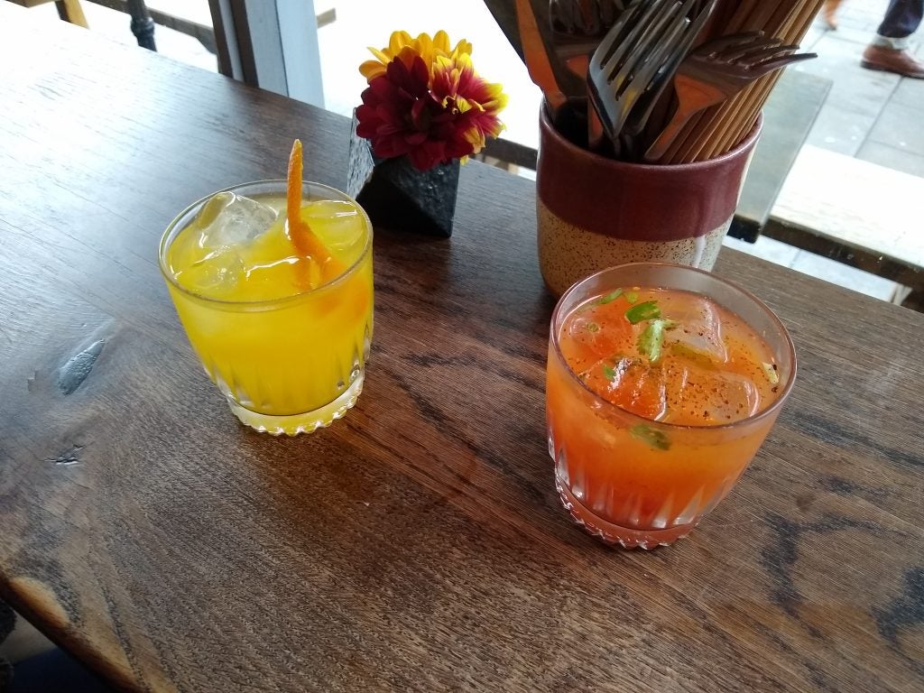 Two refreshing cocktails on a wooden table.