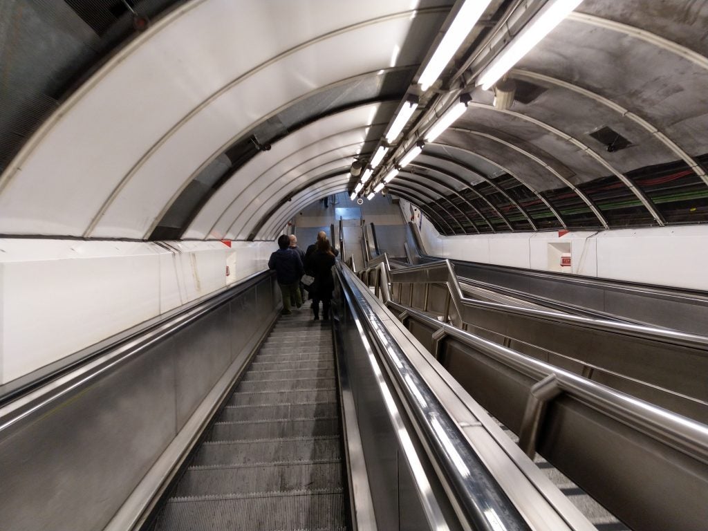 People descending on an escalator in a metro station
