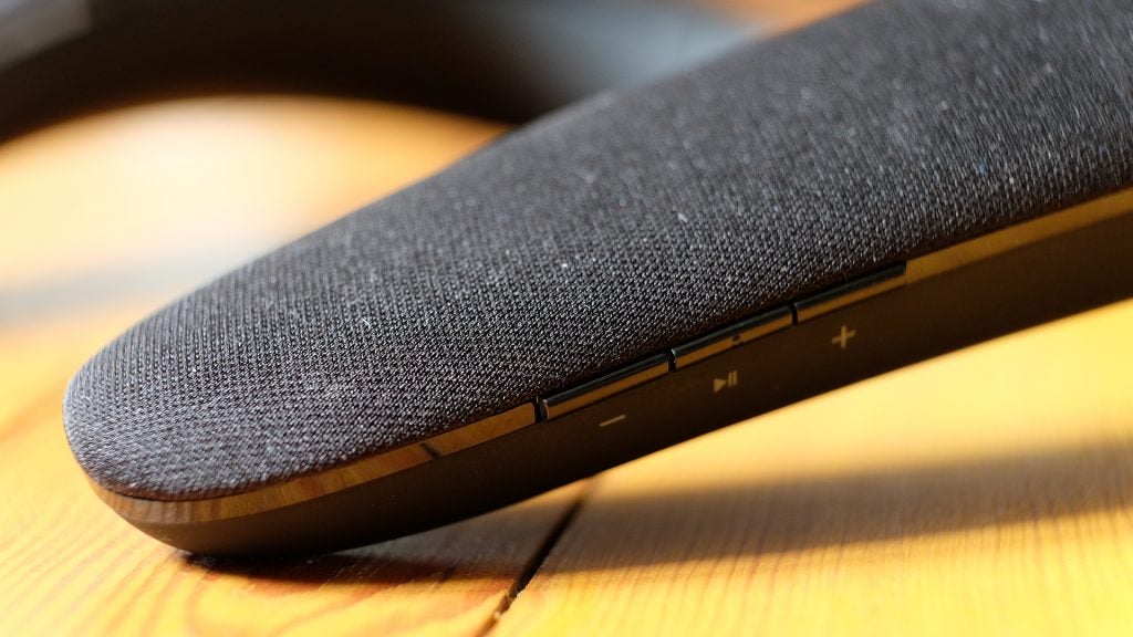 Close-up of a JBL Soundgear wearable speaker on a wooden surface.
