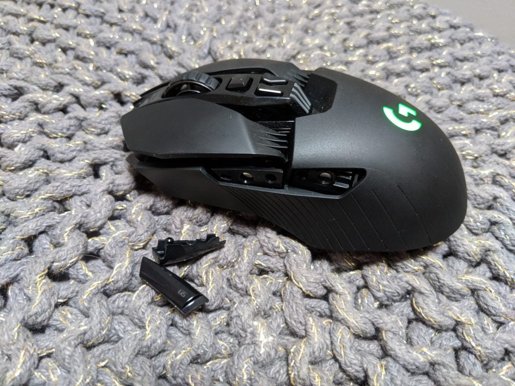 Logitech G903 wireless gaming mouse with USB dongle on fabric surface.