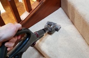 Shark Lift-Away NV681UKT vacuum cleaner in use on carpeted stairs.