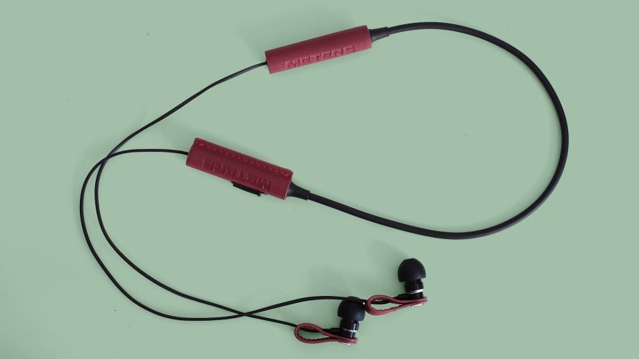 Meters M-Ear Bluetooth in-ear headphones on green background.
