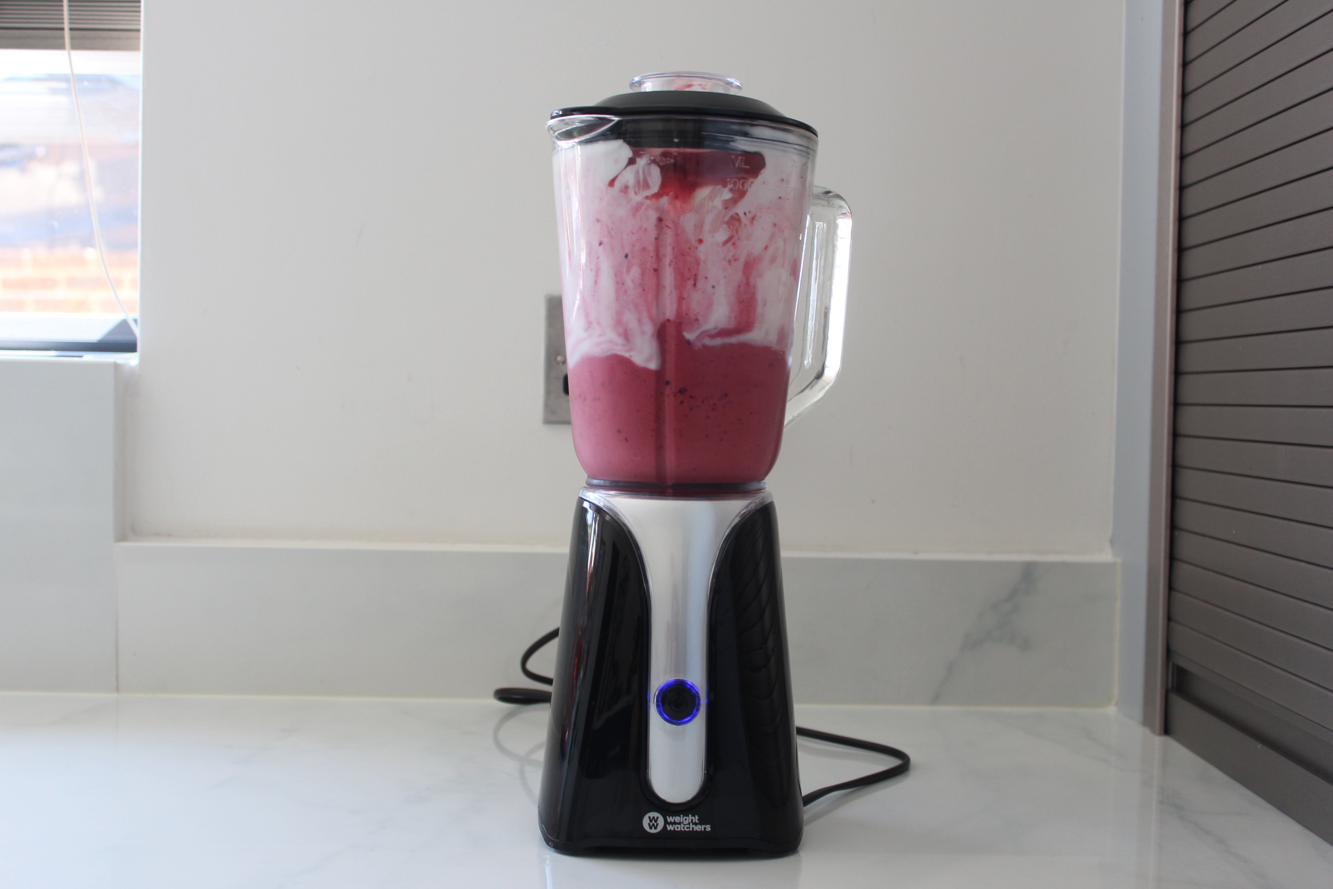 Weight Watchers blender with pink smoothie on kitchen counter.