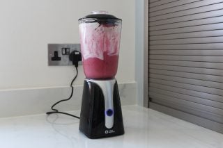 Weight Watchers blender with pink smoothie on kitchen counter.