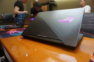 Asus ROG Strix Scar 2 laptop with illuminated logo on desk.