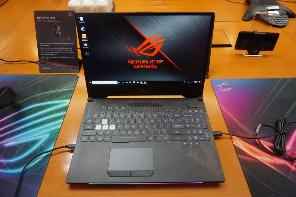 Asus ROG Strix Scar 2 laptop on desk with mouse and pad.