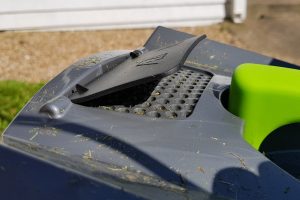 Close-up of Gtech Falcon Cordless Lawnmower with grass clippings.