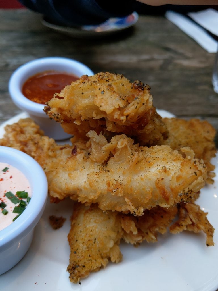 Close-up of crispy fried chicken with dipping sauces