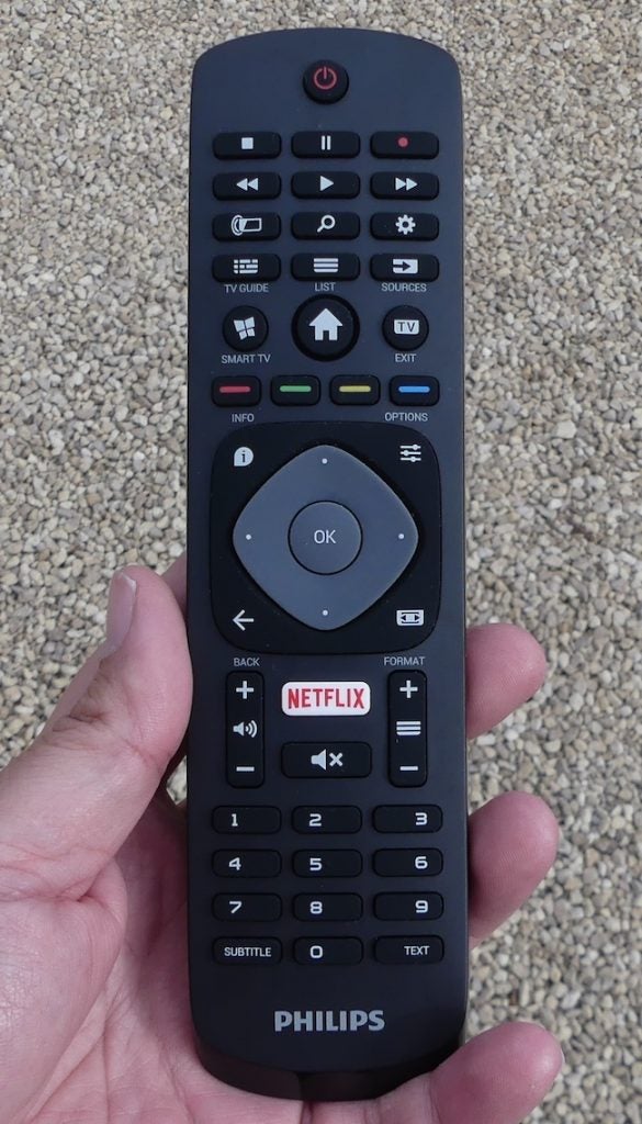 Philips TV remote control with Netflix button in hand.