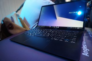Asus Zenbook S laptop on display with screen visible and keyboard.