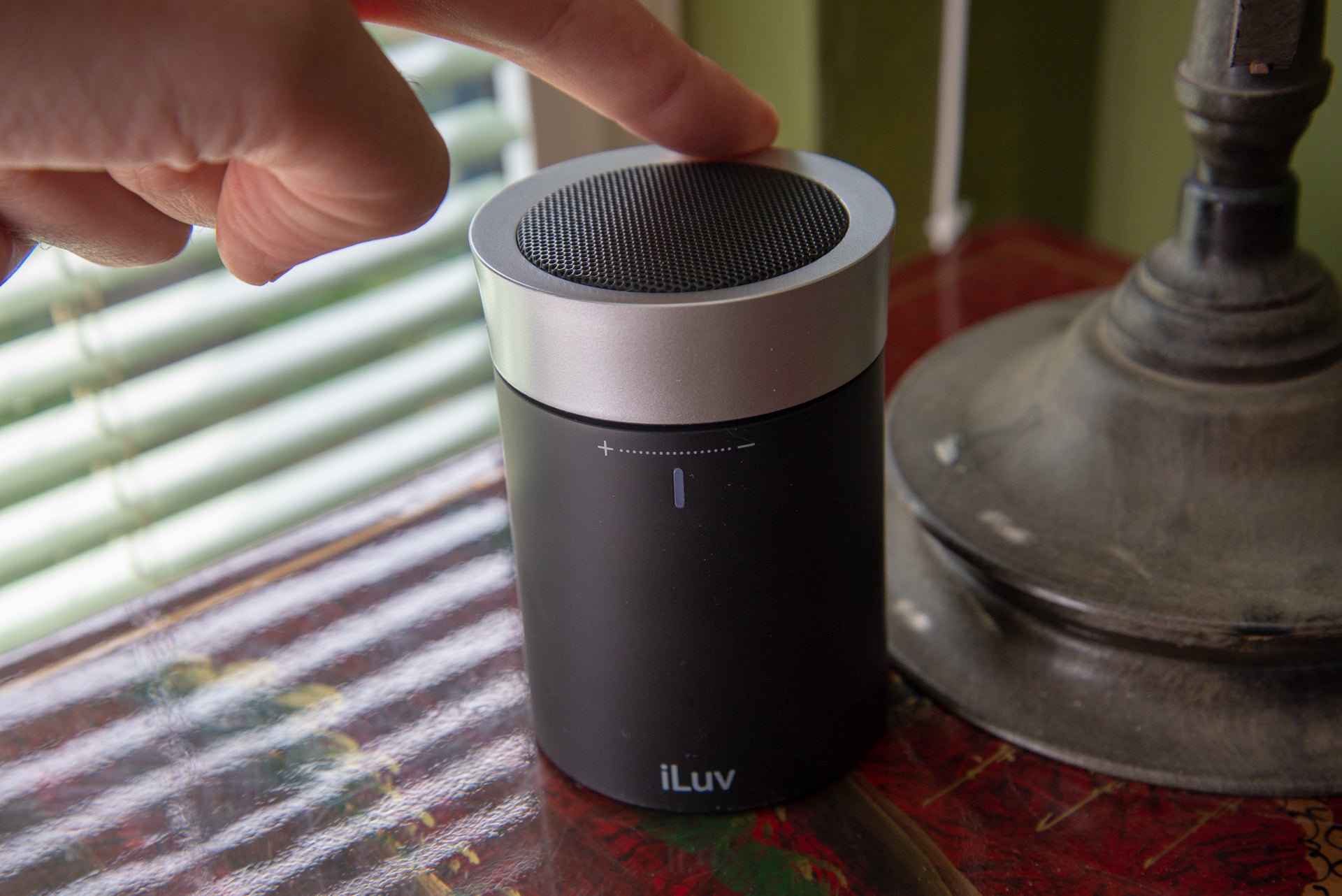 Person activating iLuv Aud Click portable speaker.