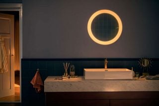 A Philips Hue Adore mirror mounted on a wall in a bathroom