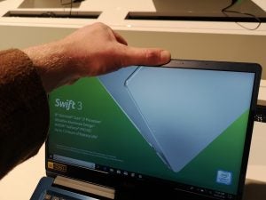 Trusted Reviews' Thomas Newton testing out how flexible the aluminium body of the Acer Swift 3 (2018) is by giving the screen a gentle squeeze.