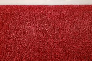 Close up view of a red carpet with white dirt on it