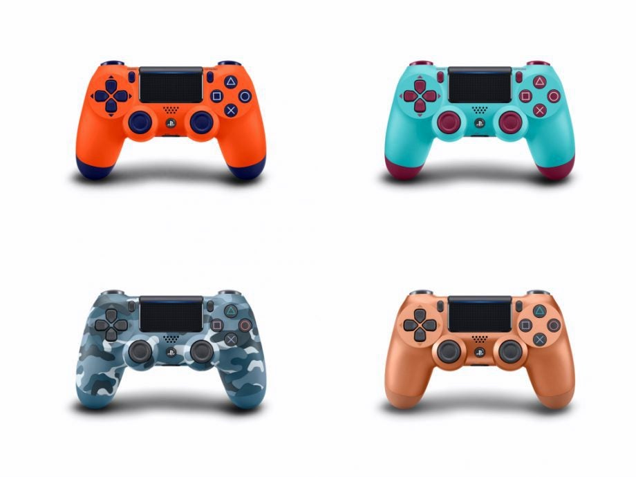 Four different colored PS4 Dualshock gaming controllers standing on white background