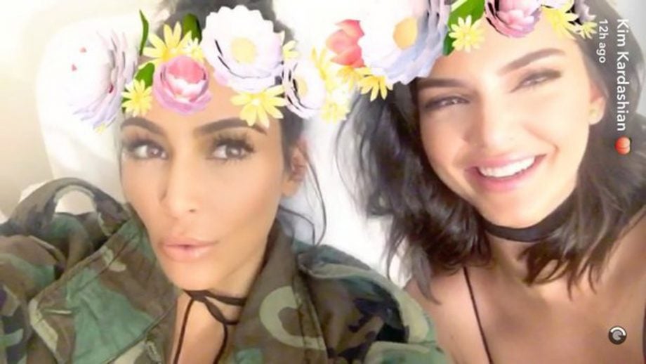 A picture of Kim Kardashian with flower crowns filter and a partner beside