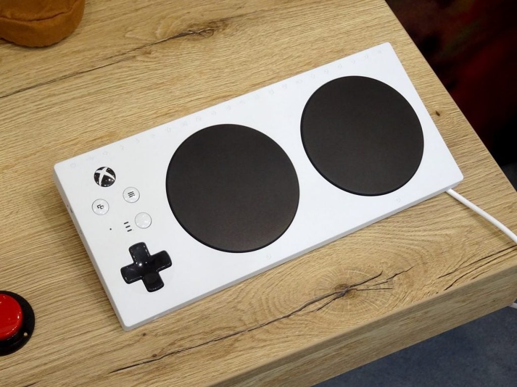 Gifts under £100 for geeks: Xbox Adaptive ControllerView from top of an Oppo smartphone laid on a wooden table displaying homescreen
