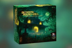A box of a game called Betrayal At House on the Hill standing on green background