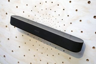 Right angled view of black Sonos Beam soudbar mounted on a white wall with holes